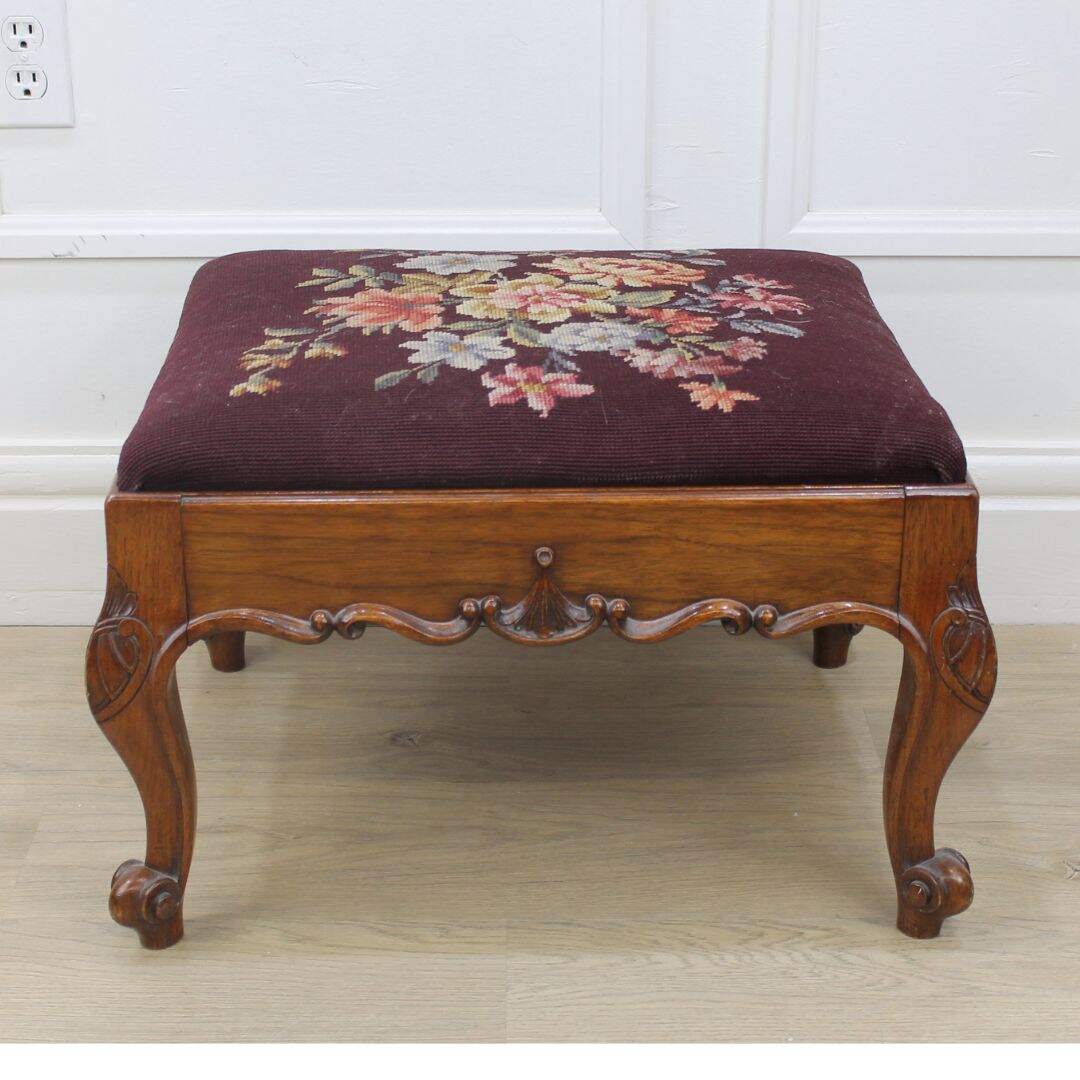 carved footstool with needlepoint