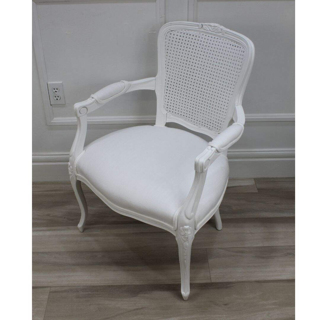 pair of white on white French chairs with caned backs