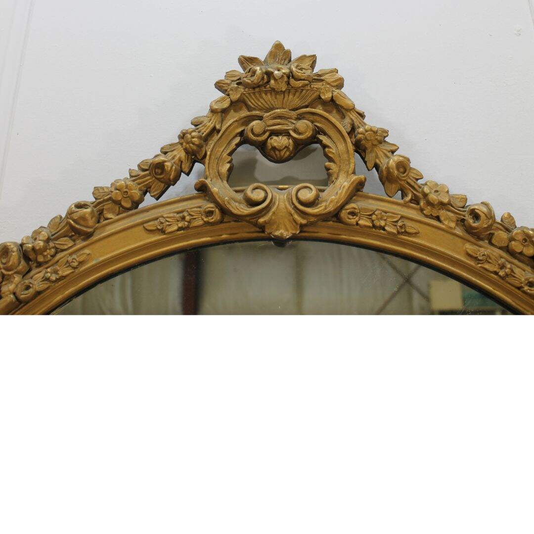 round gold mirror with floral swag detail