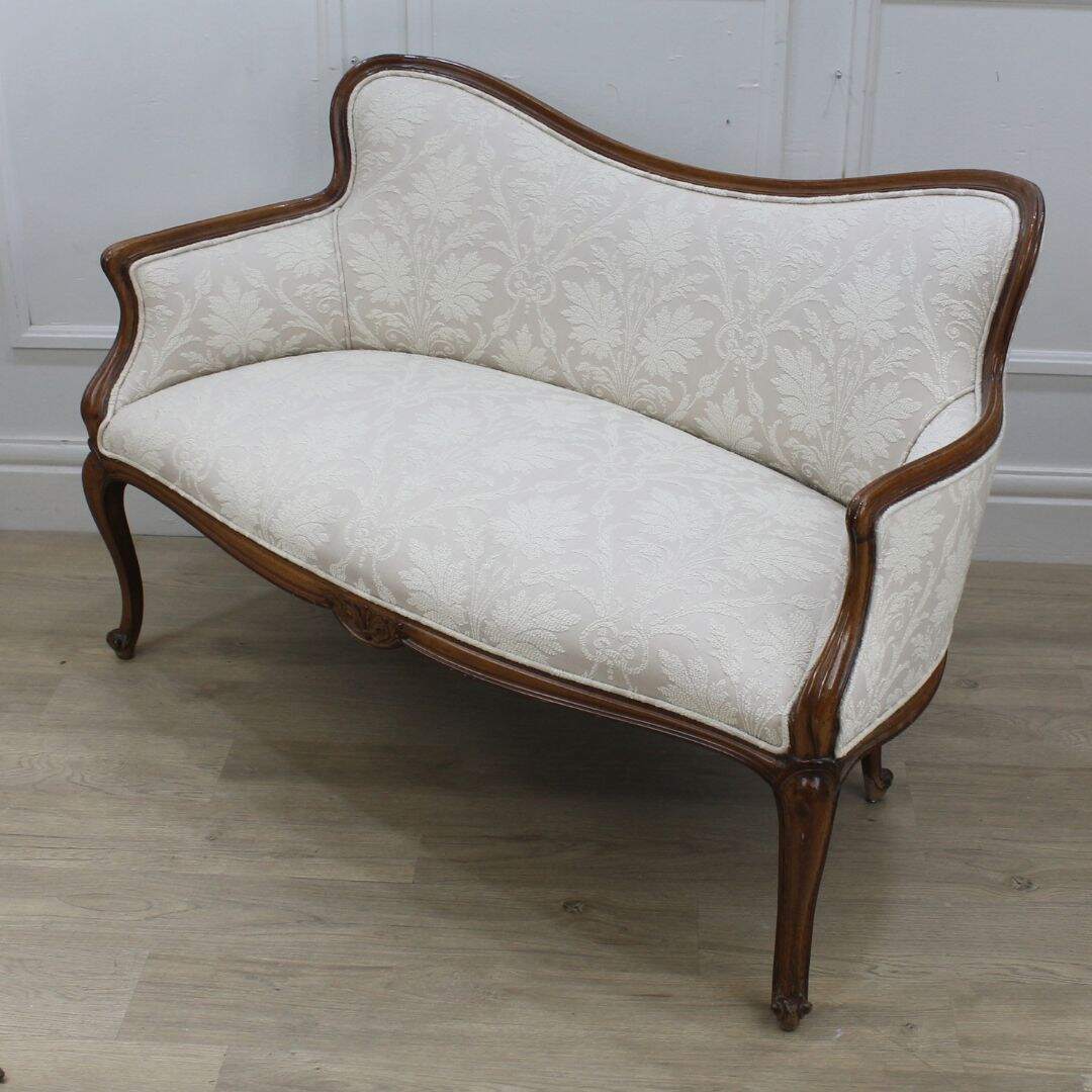 settee with carved curvy frame and beige fabric